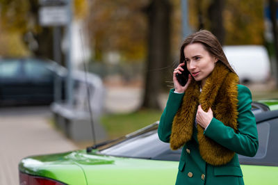 Young woman using mobile phone while sitting in car