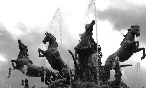 Low angle view of statues against sky
