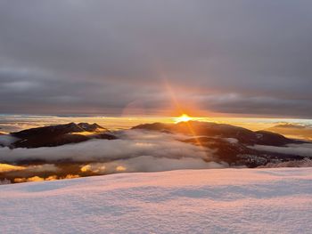 Scenic view of snow covered landscape against sky during sunset