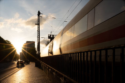 Train on bridge against sky during sunset