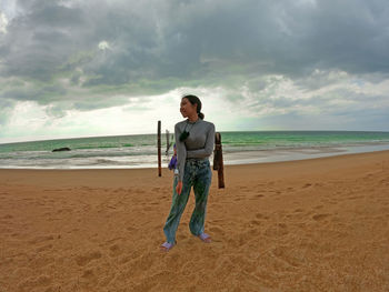 Full length of man standing on beach against sky