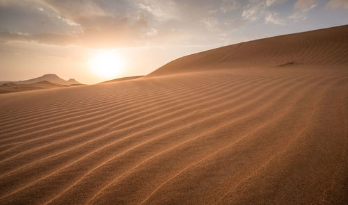 Scenic view of desert against sky during sunset