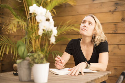 Young woman looking at while sitting on table