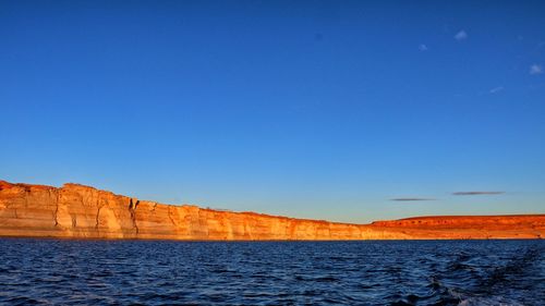 Scenic view of water against clear blue sky