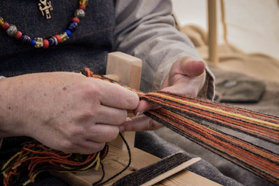 Midsection of person weaving handloom