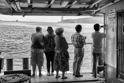 Rear view of people traveling in ferry at lake