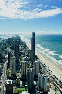 Aerial view of cityscape by sea against sky