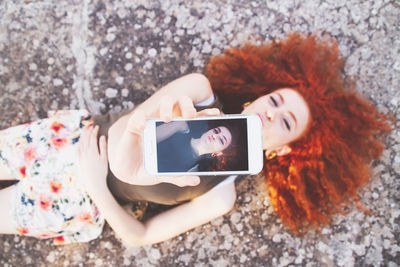 Midsection of woman photographing with mobile phone