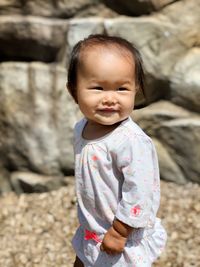 Smiling cute girl looking away while walking at beach