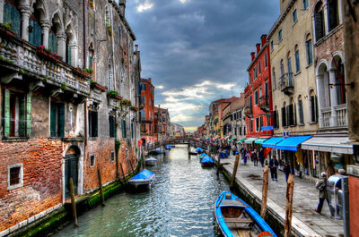 Canal amidst buildings in city against sky