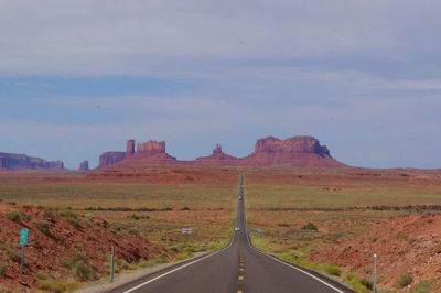 Road leading towards the monument valley against sky