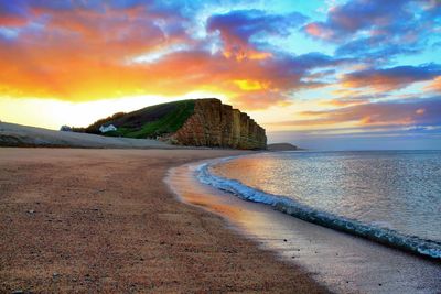 Scenic view of beach against sky during sunset