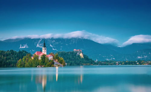 Buildings by river against sky