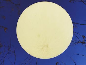 Low angle view of moon against clear blue sky