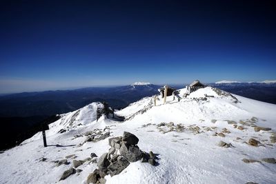 Scenic view of snowcapped mountains against clear blue sky