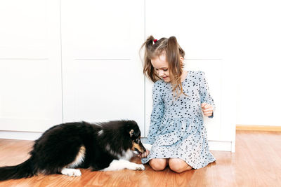 Young woman with cat on floor