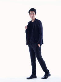 Portrait of young man standing against white background