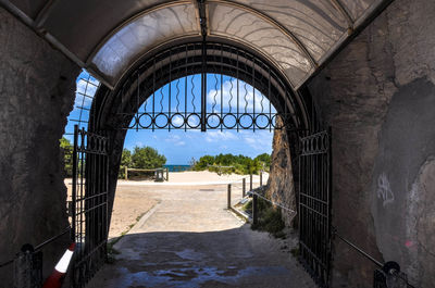 View of historic building against sky seen through archway