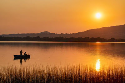 Scenic view of lake against sky during sunset