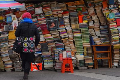 Rear view of woman walking against bookstore