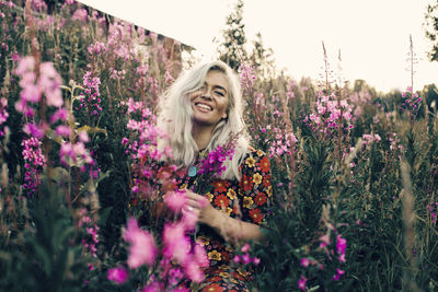 Portrait of smiling woman with purple flowers