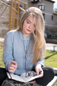 Young woman sitting with notebook