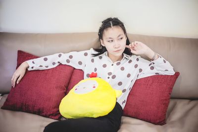 Portrait of woman sitting on sofa at home