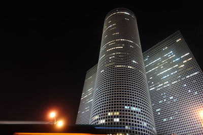 Low angle view of illuminated buildings against sky at night