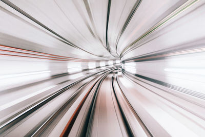 Long exposure perspective view of subway tunnel or arched passage illuminated by bright electric lights