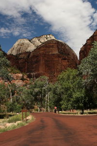 Road amidst rocks and trees against sky
