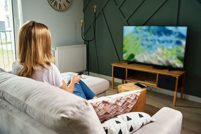 Woman sitting on bed at home