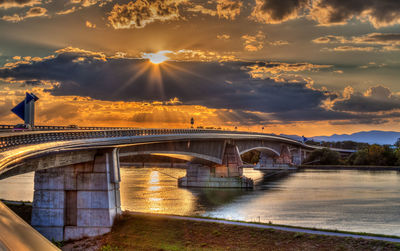 Bridge over river against sky during sunset