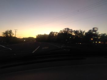 Cars on street seen through windshield during sunset