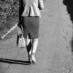 Low section of woman walking on road