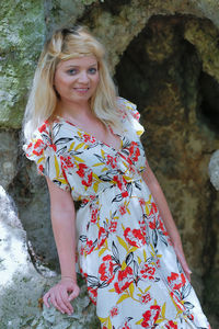 Portrait of smiling woman standing against tree