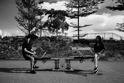 Rear view of man and woman playing soccer against sky