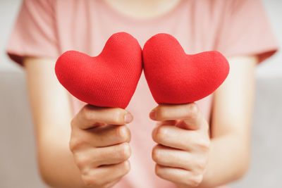 Midsection of woman holding red heart shape