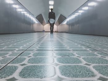 Low section of man walking on tiled floor