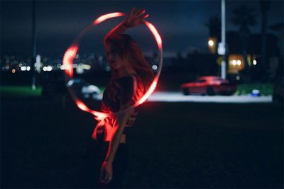 Man with illuminated lighting equipment at night