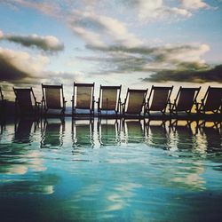 Row of deck chairs by infinity pool