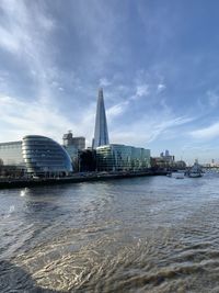 View of city by river against sky