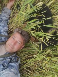 High angle portrait of young man on plant at field