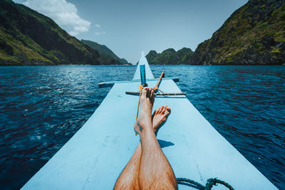 Man on boat in sea against sky