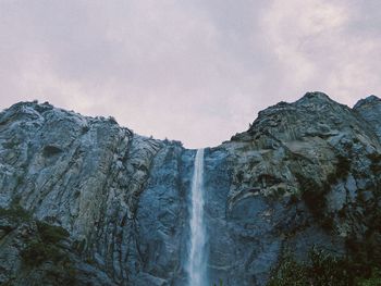 Low angle view of waterfall against sky