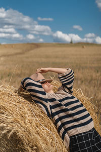 Midsection of woman on field against sky