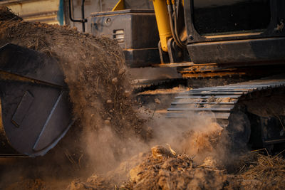 Selective focus on metal bucket teeth of backhoe digging soil. backhoe working by digging soil