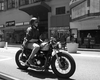 Man riding motor scooter on road