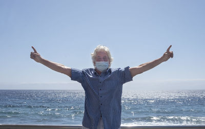 Woman standing by sea against clear sky