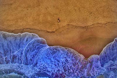 Midsection of person on rock at shore
