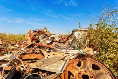 Abandoned car on field against sky